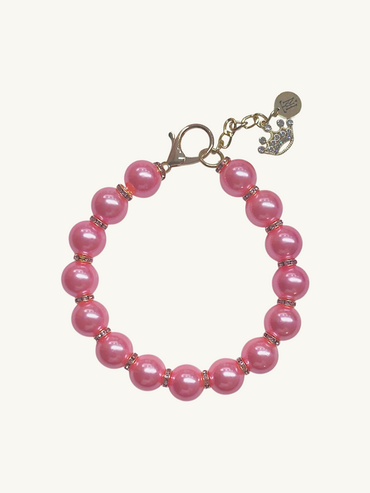 Pink beaded bracelet with a gold clasp on a white background