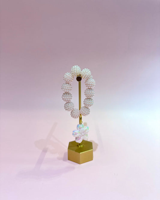 Decorative object with spherical beads on a pink background
