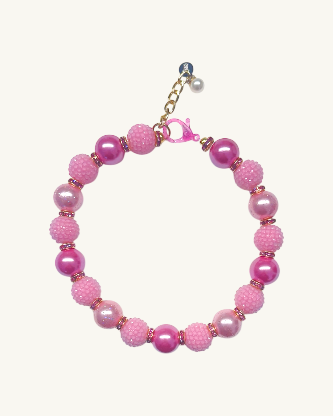 Pink beaded bracelet with a gold clasp on a white background