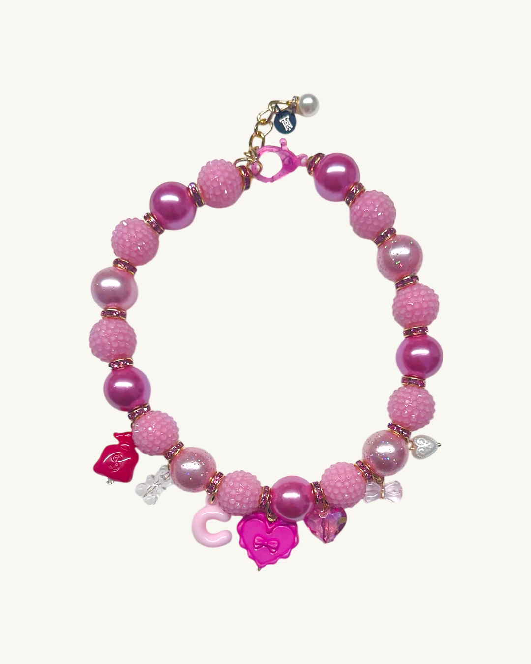 Pink beaded bracelet with charms on a white background