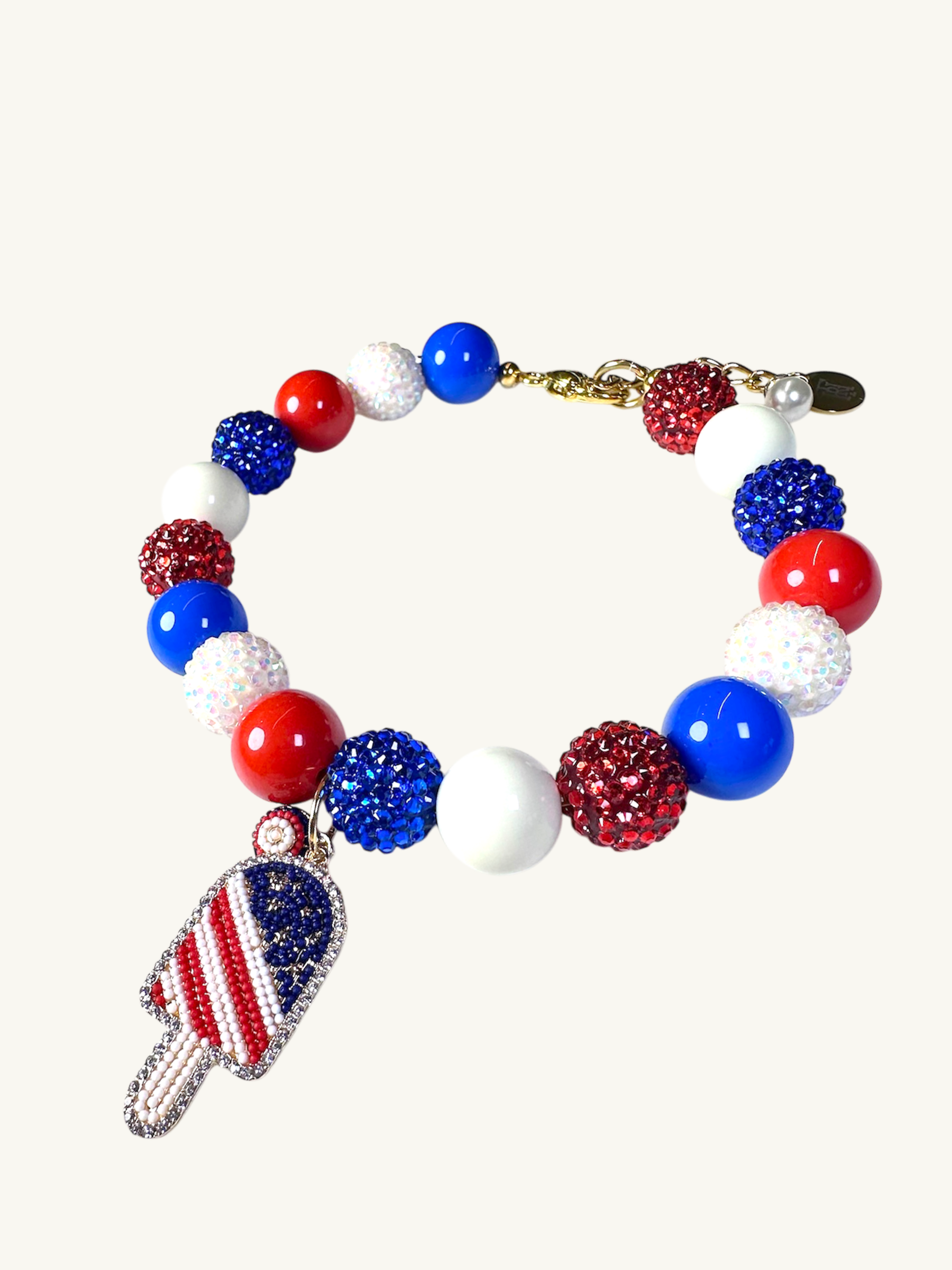 A pet luxury beaded necklace handmade in New York City in red, white, and blue with ice cream popsicle charm as part of The Haus Royale's The Americana collection