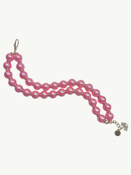 Pink beaded necklace with a silver clasp on a white background