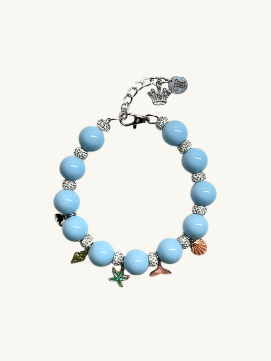 Bracelet with blue beads and various charms on a white background