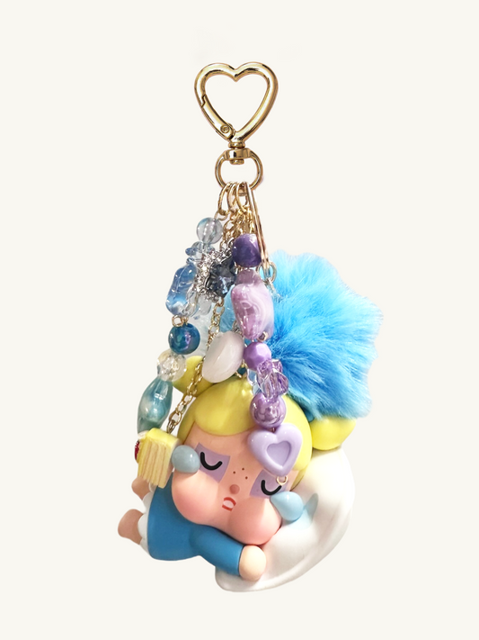 Colorful keychain with a sleeping baby doll design on a white background