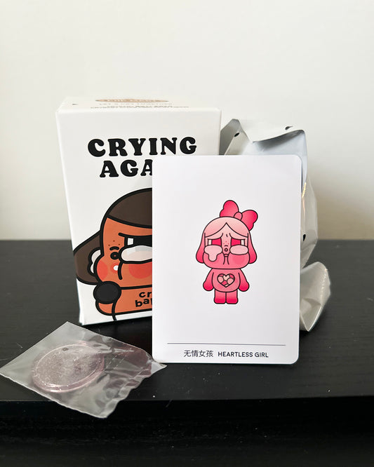 Card with a pink character and text 'Heartless Girl' on a black surface.