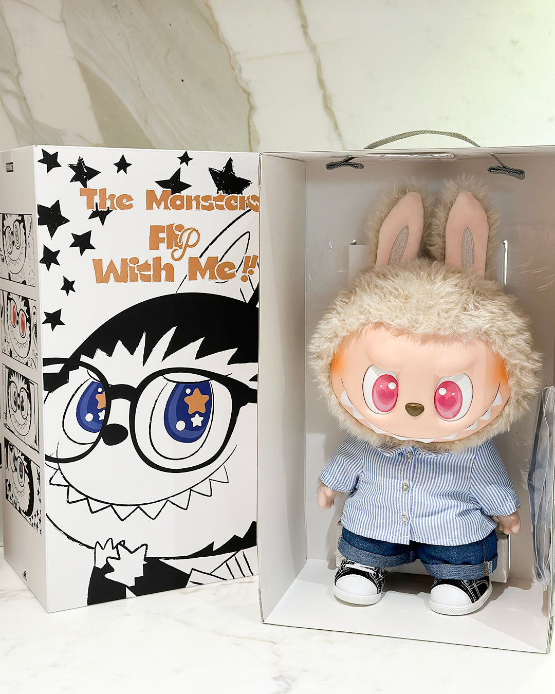Plush toy with bunny ears in a box with cartoon face design