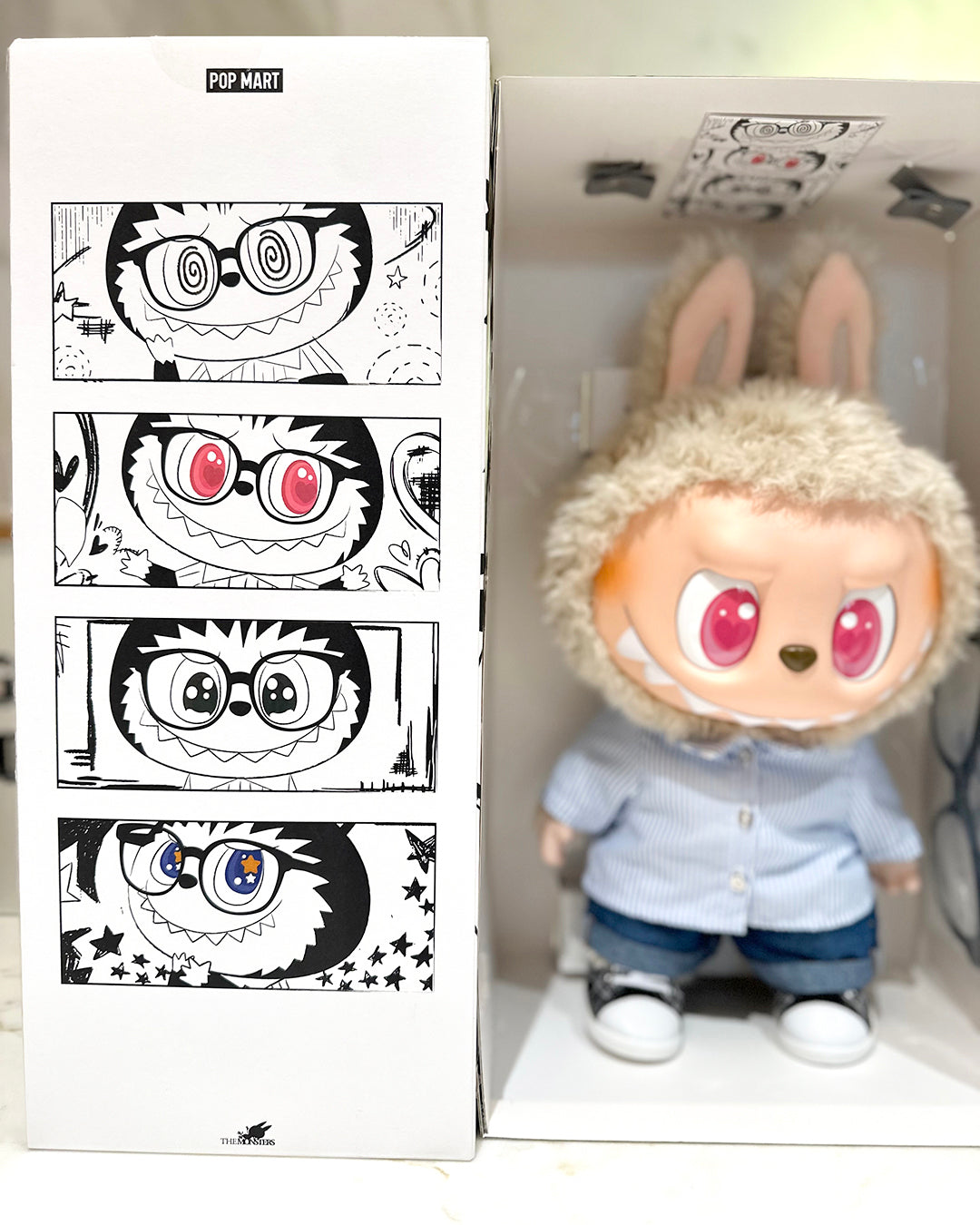 Toy figure with bunny ears next to a box with character designs