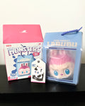 Lalubu toy with packaging and card on a black surface