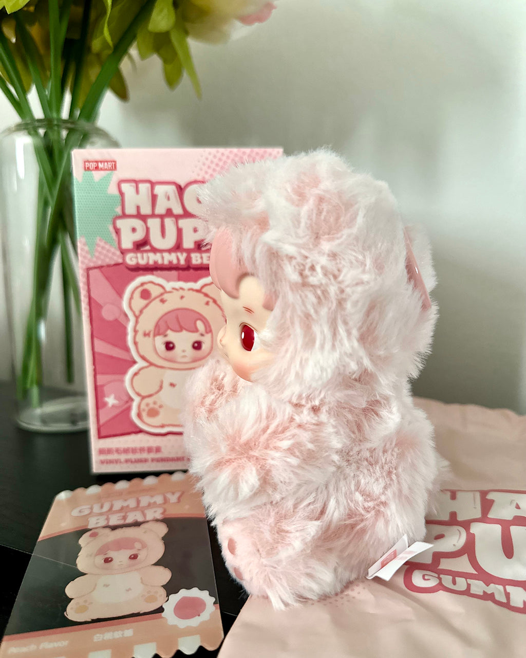 Pink plush toy with packaging on a surface