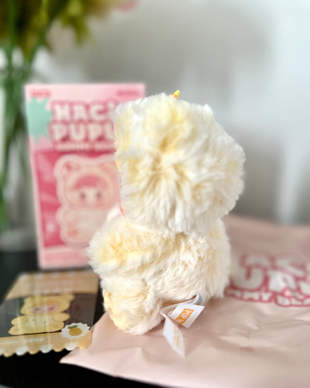 White plush toy with a pink box in the background