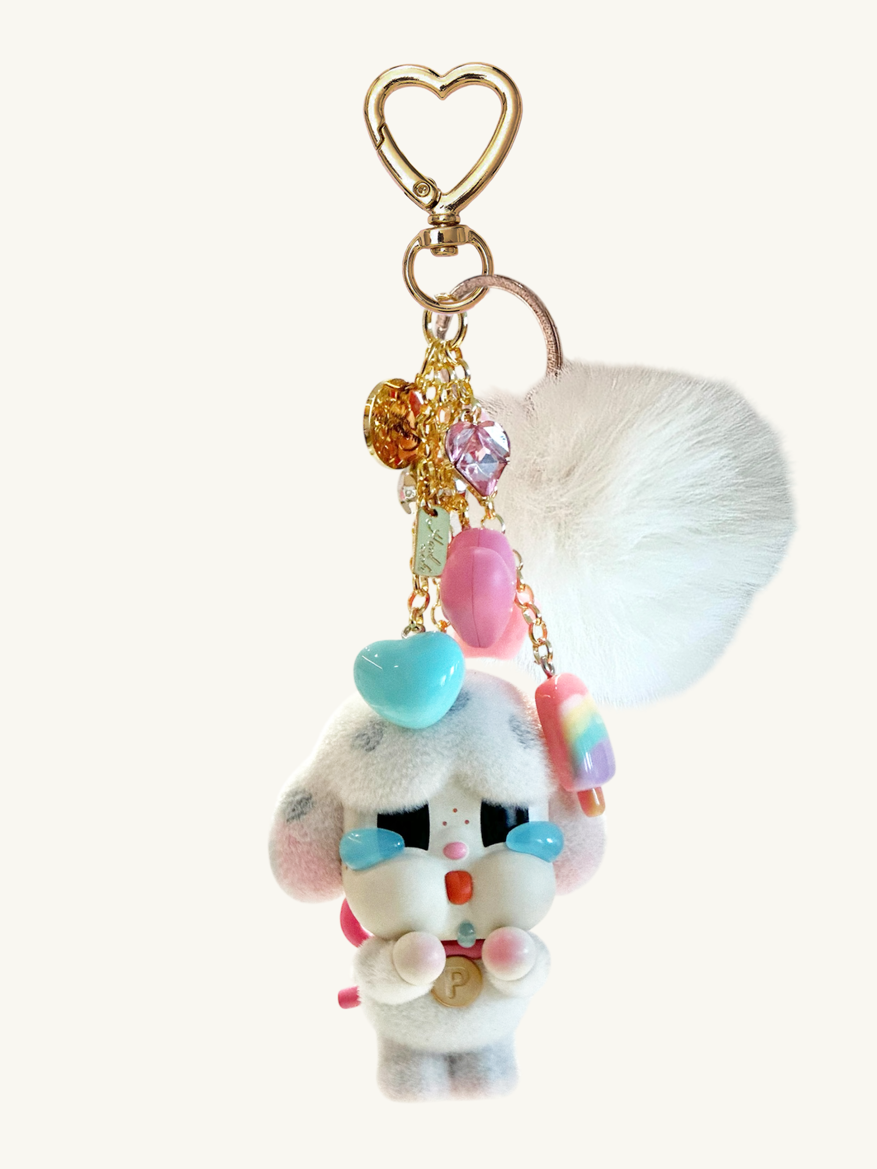 Plush keychain with colorful beads and heart-shaped clip on a white background