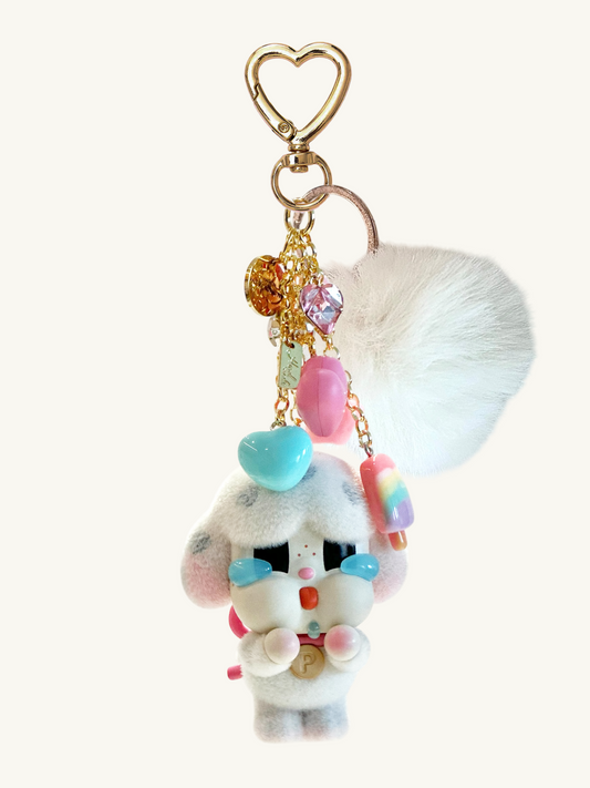 Plush keychain with colorful beads and heart-shaped clip on a white background