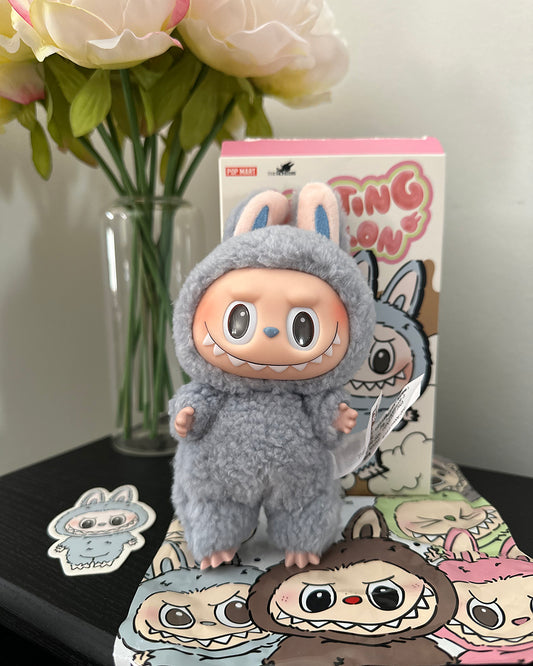 Plush toy in a costume with a box and stickers on a table