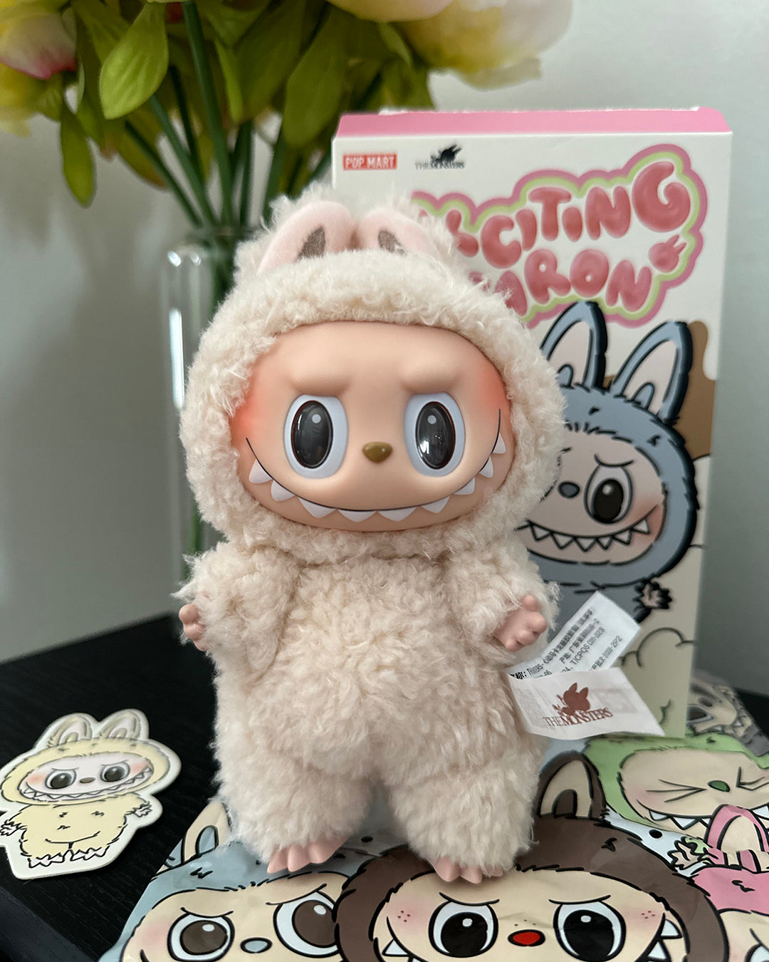 Plush toy with a character design, brand box in the background