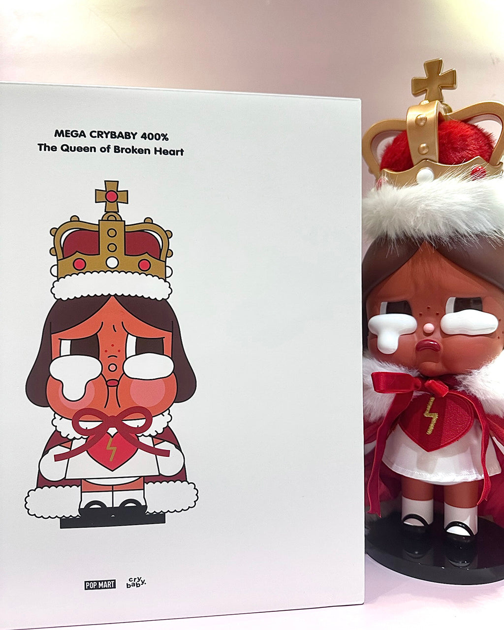 Toy figure with a crown and white outfit next to its packaging